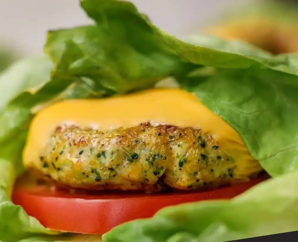 Broccoli Cheddar Chicken Burgers served on a plate with fresh ingredients.