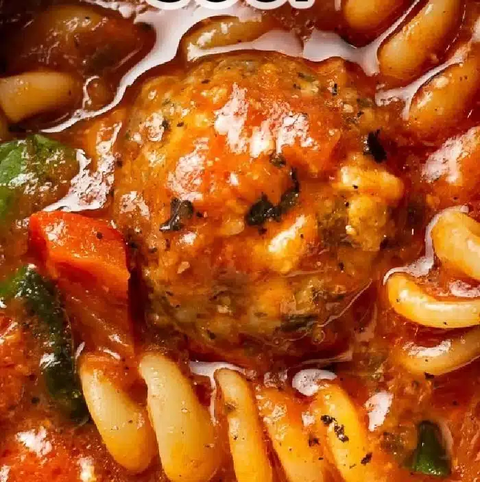 Bowl of simple meatball soup with fresh herbs and vegetables