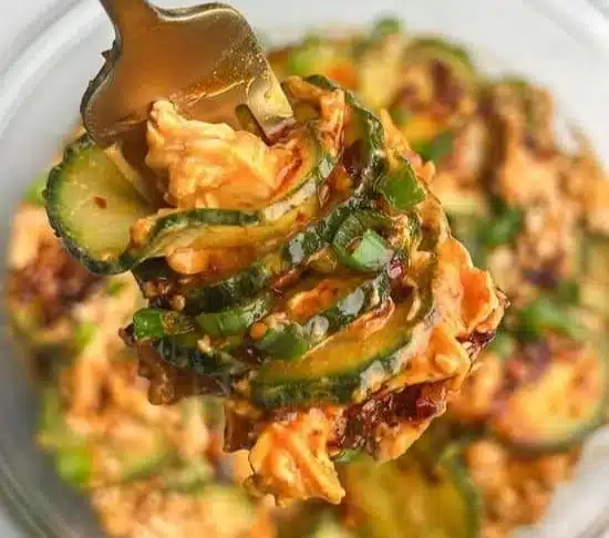 Thai cucumber salad with chicken, featuring fresh vegetables and vibrant herbs.